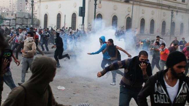 Egyptians in central Cairo ran from tear gas during clashes with the police on Friday February 1, 2013.