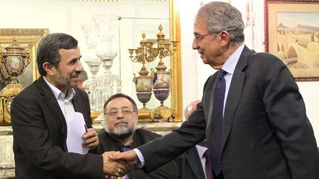 Iranian President Mahmoud Ahmadinejad (L) shakes hands with former secretary general of the Arab League Amr Mousa in Cairo on February 7, 2013.