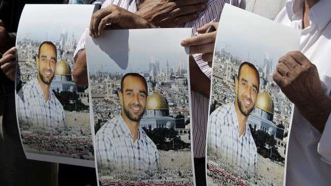 Protesters hold portraits of Palestinian prisoner Samer Issawi during a solidarity sit-in outside the Red Cross office in al-Quds (Jerusalem), September 18, 2012.