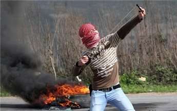 Protester uses a sling shot to throw stones towards Israeli forces during clashes at Hawara checkpoint near the West Bank city of Nablus March 1, 2013.