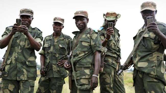 Congolese army soldiers use mobile phones to record videos in the town of Sake, about 27 kilometers west of Goma, on December 3, 2012.