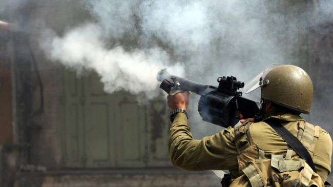 An Israeli soldier fires a tear gas canister during clashes with Palestinians in the West Bank city of al-Khalil (Hebron) following the death of a Palestinian prisoner in an Israeli jail, April 2, 2013.