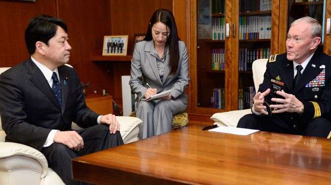 Japanese Defence Minister Itsunori Onodera (L) chats with General Martin Dempsey (R), chairman of the US Joint Chiefs of Staff, as an interpreter (C) takes notes, during their talks at the Defence Ministry in Tokyo on April 26, 2013.