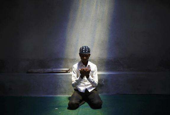 A Nepalese Muslim boy offers Friday prayers during the Muslim holy month of Ramadan in Kathmandu July 12 2013.