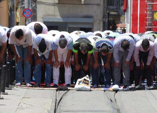 Muslim men pray during Friday prayers during the Muslim holy month of Ramadan along a street next to Taksim Square in Istanbul July 12 2013.