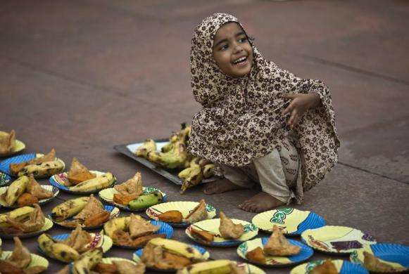 A Muslim girl arranges plates before iftar (breaking fast) meal on the first day of the holy month of Ramadan in India at the Jama Masjid (Grand Mosque) in the old quarters of Delhi July 11 2013.