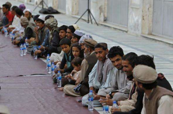 Afghan Muslims wait for their Iftar meal on the first day of Ramadan the holiest month in the Islamic calendar at a mosque in Kabul July 10 2013.