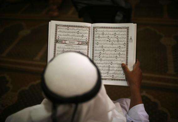 A Palestinian man recites the Quran at al-Omari mosque in Gaza City during the first day of the holy fasting month of Ramadan July 10 2013.