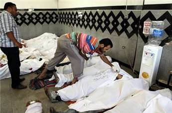 Men check the identity of dead Muslim Brotherhood supporters in a field hospital in Cairo on July 27.