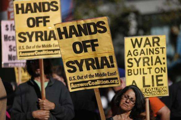 Demonstrators hold signs during a rally in opposition to the proposed military intervention against Syria in San Francisco August 29 2013.