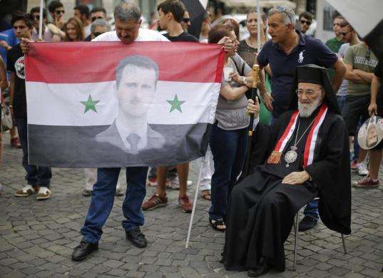 Hilarion Capucci (R) of the Melkite Greek Catholic Church takes part in a rally in support of Syrian President Bashar al-Assad in downtown Rome August 30 2013.