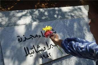 A Palestinian woman places a flower at the Palestinian Martyr