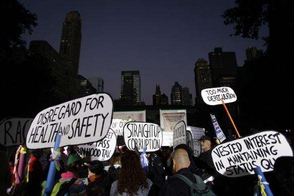 Occupy Wall Street protesters hold up placards in Bryant Park in New York September 17 2013.