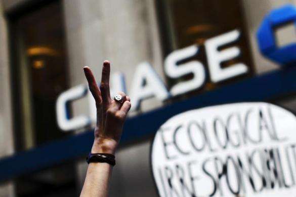 An Occupy Wall Street protestor flashes a peace sign during a march on Broadway past a Chase bank in New York financial district September 17 2013.