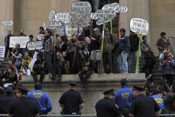Occupy Wall Street protesters stand on the steps of Federal Hall across the street from the New York Stock Exchange in New York September 17 2013.