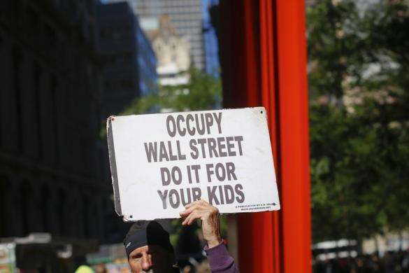 An Occupy Wall Street protester stands outside a barricade at Zuccotti Park in New York September 17 2013.