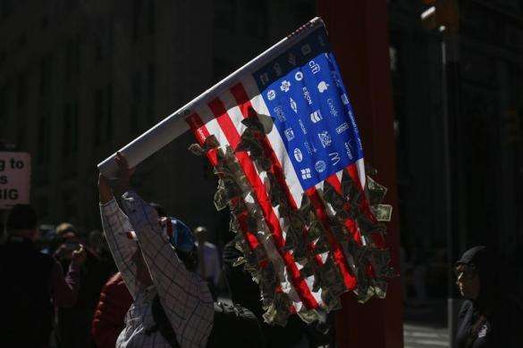 An Occupy Wall Street protester marches outside a barricade at Zuccotti Park in New York September 17 2013.