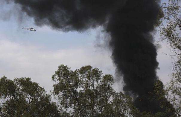 A helicopter flies as smoke rises over Westgate shopping centre after an explosion in Nairobi September 23 2013.