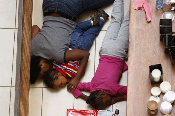 A mother and her children hide from gunmen at Westgate Shopping Centre in Nairobi September 21 2013.