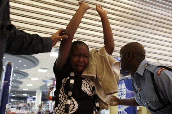 A girl is helped by police officers inside Westgate Shopping Centre in Nairobi September 21 2013.