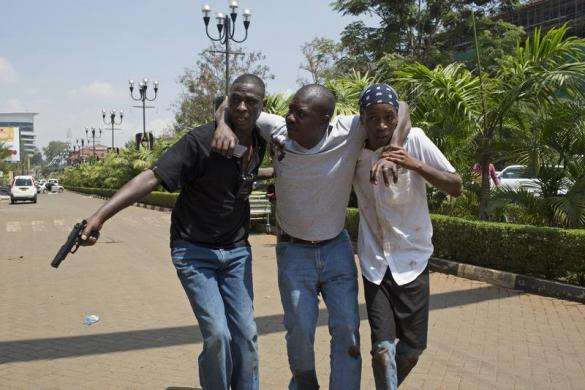 A man (C) is helped out of Westgate Shopping Centre where gunmen went on a shooting spree in Nairobi September 21 2013.