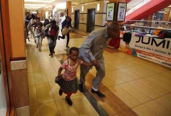 People with children run for safety as armed police hunt gunmen who went on a shooting spree at Westgate shopping centre in Nairobi September 21 2013.