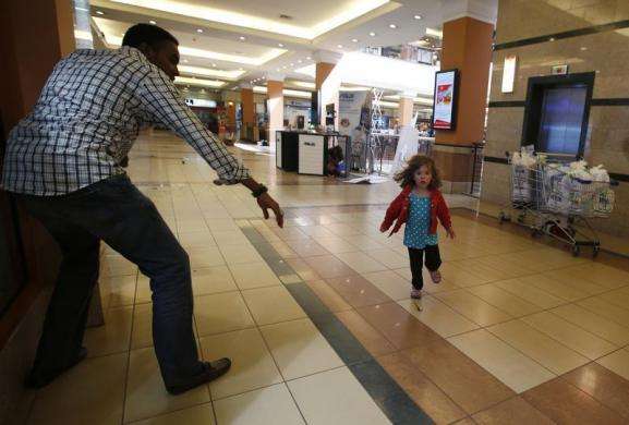 A child runs to safety as armed police hunt gunmen who went on a shooting spree at Westgate shopping centre in Nairobi September 21 2013.