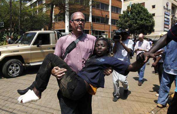 A journalist rescues a woman injured in a shootout between armed men and the police at the Westgate shopping mall in Nairobi September 21 2013.