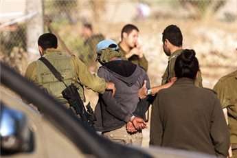 Israeli soldiers escort a detained Palestinian man in the Israeli Brosh settlement at the Jordan Valley in the West Bank on Oct. 11, 2013 after an Israeli man was bludgeoned to death