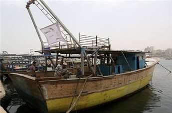 Palestinian fishermen work to transform a large fishing boat into "Gaza Ark" in Gaza City.