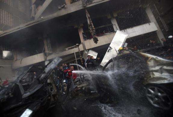 People attempt to extinguish a fire at the site of an explosion in Beirut southern suburbs January 2 2014.