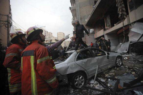 Civil defence personnel inspect a damaged building at the site of an explosion in Beirut southern suburbs January 2 2014.
