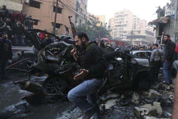 A man holds a rifle at the site of an explosion in Beirut southern suburbs January 2 2014.