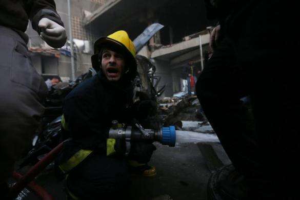 Firefighters attempt to extinguish a fire following an explosion in Beirut southern suburbs January 2 2014.