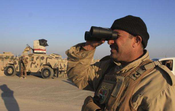 An Iraqi soldier uses a binoculars at a checkpoint in Ein Tamarm a town some 25 miles west of Kerbala January 7 2014. Families fled violence in the Iraqi cities of Falluja and Ramadi with many arriving in the predominantly Shia town of Kerbala 53 miles s