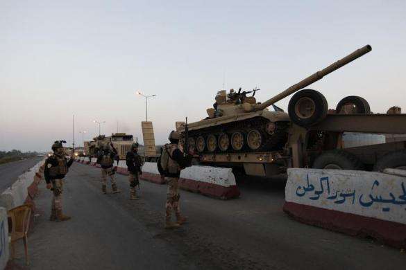 A military convoy carrying a tank drives towards Anbar to reinforce Iraqi troops in the province west of Baghdad January 6 2014.