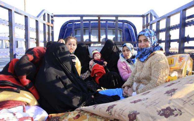Families fleeing the violence in the Iraqi cities of Falluja and Ramadi wait at a checkpoint in Ein Tamarm a town some 25 miles west of Kerbala January 6 2014.