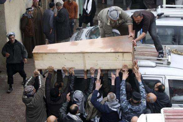 Mourners carry the coffin of a soldier who was killed during clashes in Falluja at his funeral in Najaf 99 miles south of Baghdad January 5 2014. Iraqi government forces battling an al Qaeda offensive near the Syrian border launched an air strike on Rama