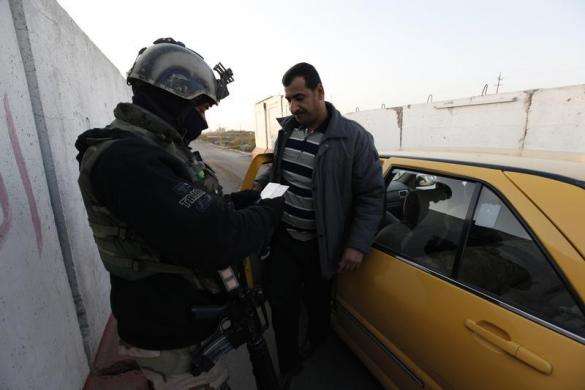 An Iraqi soldier checks identification papers at a check point west of Baghdad January 6 2014.