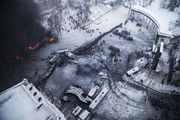 An aerial view shows riot police and Interior Ministry members standing in formation as tires set ablaze by pro-European protesters burn during clashes in Kiev January 22 2014.