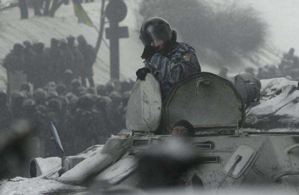 Riot police officers look out from an armored vehicle during clashes with pro-European protesters in Kiev January 22 2014.