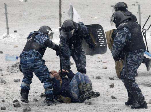 Riot police officers hold a man lying on the ground during clashes between police and pro-European protesters in Kiev January 22 2014.