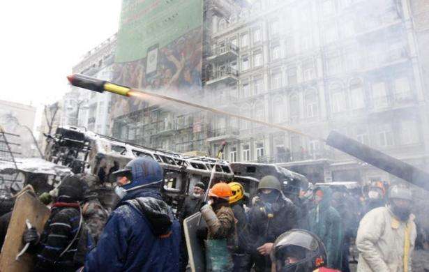 Pro-European protesters launch a pyrotechnic pistol towards riot police during clashes in Kiev January 22 2014.