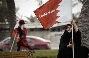 A Bahraini woman holds a national flag during an anti-government protest in the village of Aali, south of the capital Manama, on Feb. 7, 2014