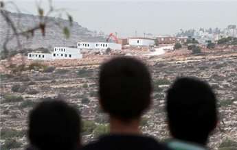Palestinian children look at bungalows built by Israeli settlers on seized land, near Birzeit on Dec. 3, 2013