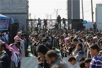 Palestinians pray near the gate of the Rafah border crossing with Egypt on February 28, 2014, during a protest to demand that Egypt lift border crossing restrictions.