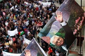 Posters of President Mahmoud Abbas are strung across the square as Palestinians rally in the center of the West Bank city of Ramallah on March 17, 2014