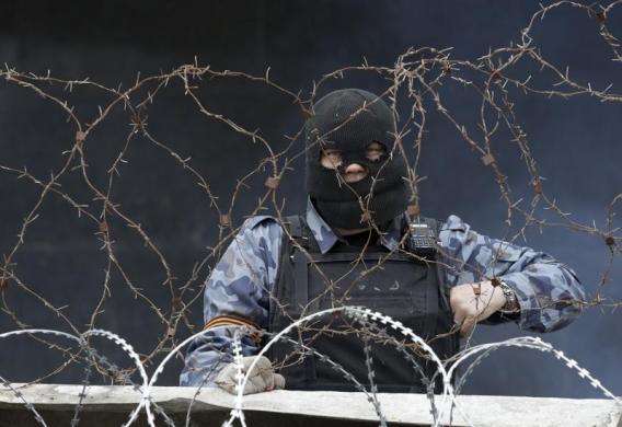 A pro-Russia protester stands at a barricade outside a regional government building in Donetsk Ukraine April 10 2014.