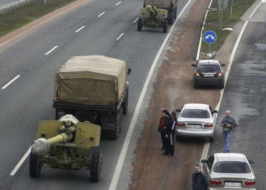 Motorists watch a Ukrainian military convoy pass by near the city of Donetsk April 10 2014.