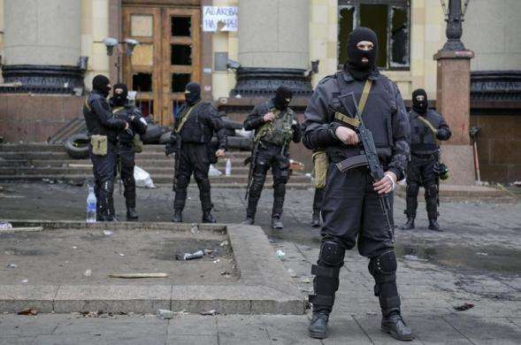 Armed men in masks representing Ukrainian special forces stand guard outside the regional administration building in Kharkiv April 8 2014.